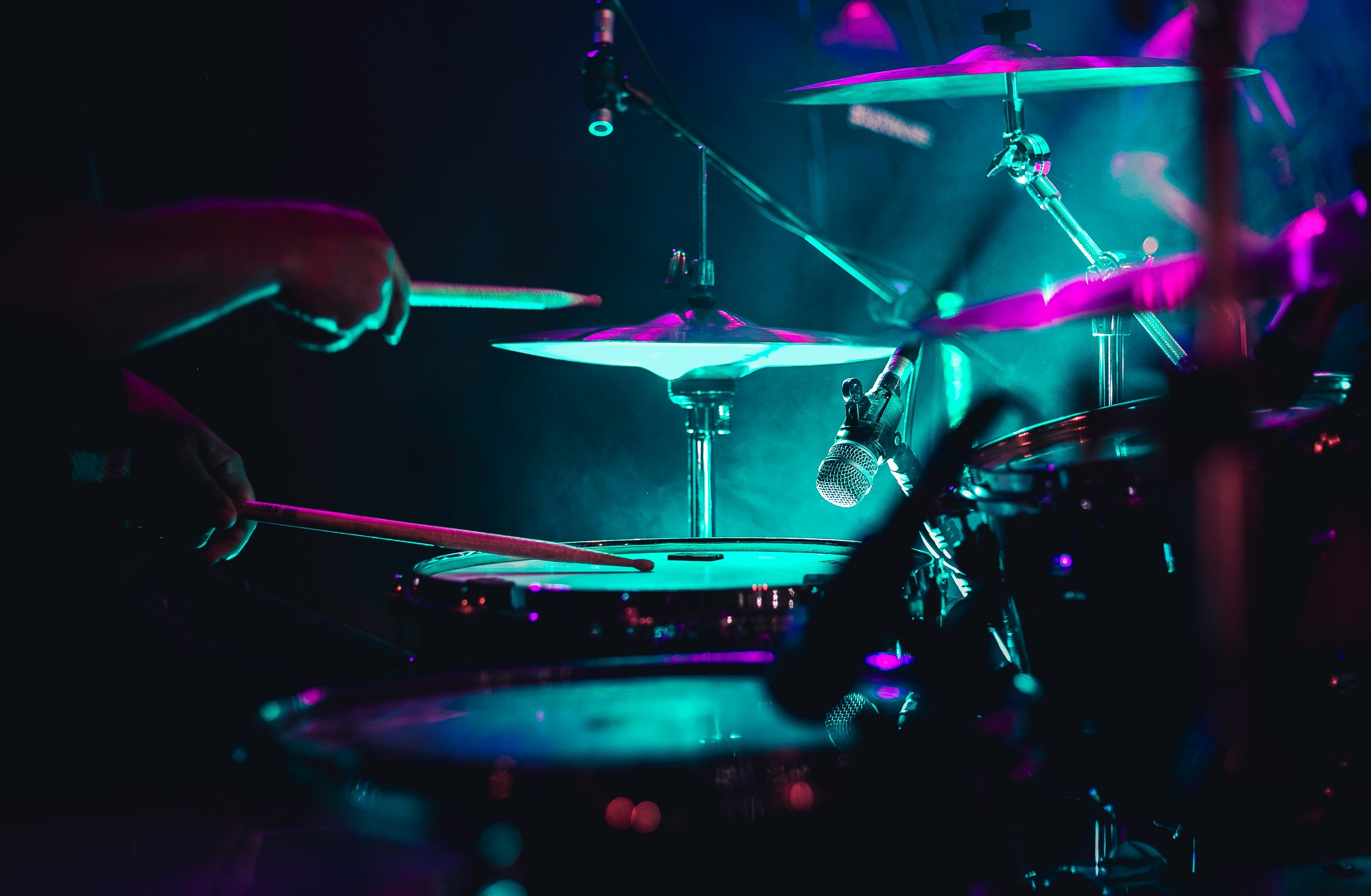 Close-up hi-hat cymbals under stage lighting